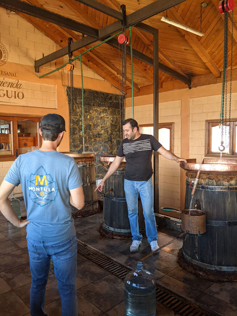 Three large stills in a row inside of a wooden cabin-like building