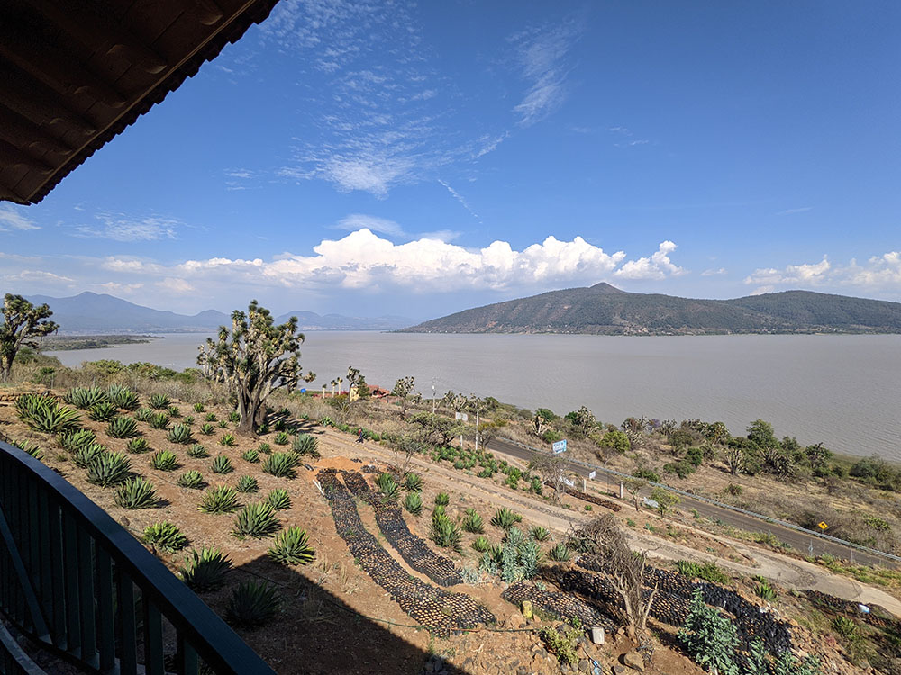 View of the Oponguio farm in a dry and arid environment, lake and mountain in the background.