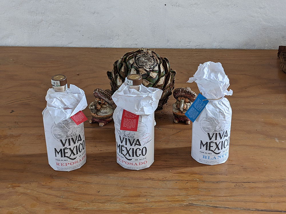 Three bottles of reposado on a wooden table