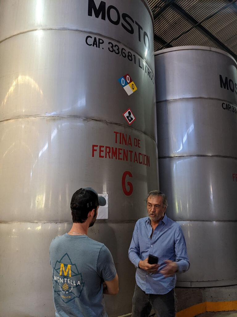Large metal fermentation silos, about three times the height of an average human